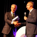Metaalunie-voorzitter Fried Kaanen neemt het jubileumboek in ontvangst uit handen van Sales director Erik Spikmans van MCB