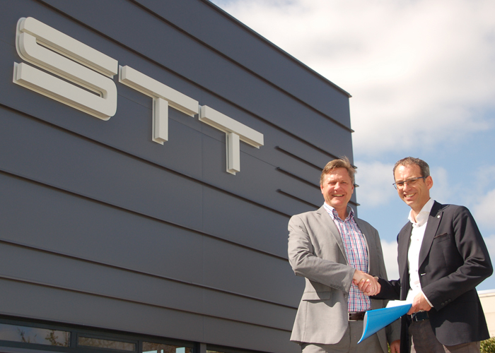 Menno Kooistra (rechts) van STT Products en Martin van der Have van ABB Robotics schudden elkaar de hand bij het nieuwe pand van STT Products in Tolbert, dat op 20 mei feestelijk wordt geopend.