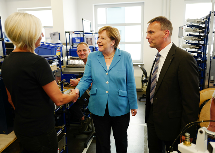 Bondskanselier Merkel in gesprek met medewerkers van Trumpf