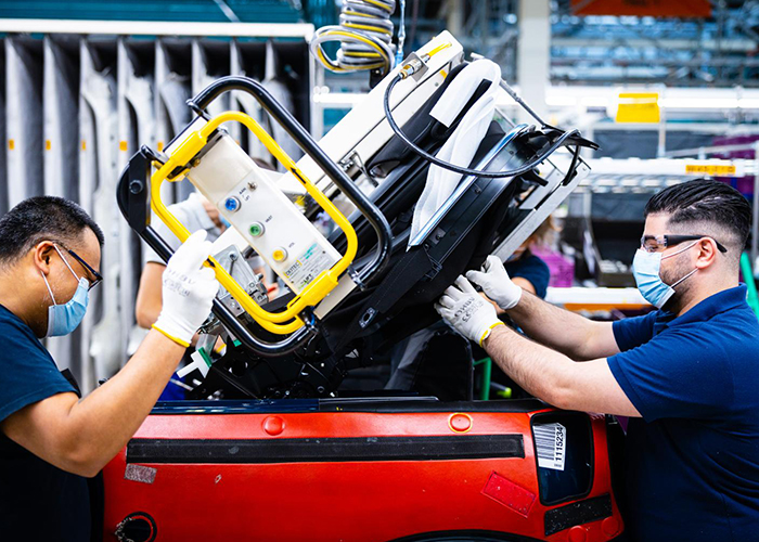 Medewerkers van VDL Nedcar die aan de assemblagelijn dicht bij elkaar werken, zijn onder meer uitgerust met persoonlijke beschermingsmiddelen, zoals mondkapjes, veiligheidsbrillen en handschoenen. (Foto: VDL)