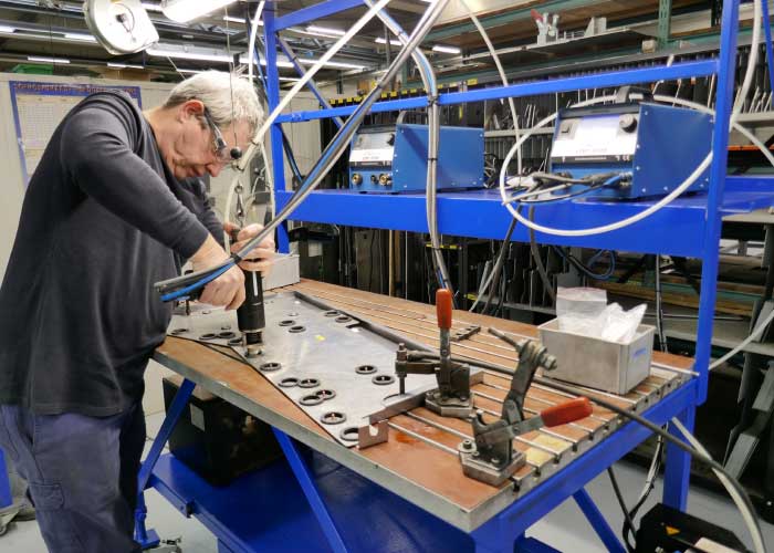 Lascoördinator Jan Gielens demonstreert het stiftlassen. De twee stiftlasmachines bevinden zich op ooghoogte. Hierdoor kan de persoon die het stiftlaspistool bedient alle informatie van het display aflezen terwijl hij last.