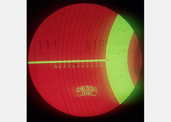 Het zicht in de microscoop. Elk streepje rechts is 0,001 mm.