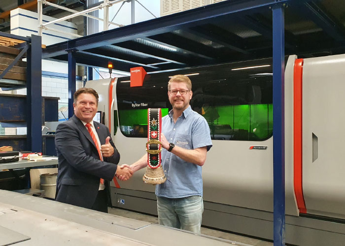 Jan Berends (links) van Bystronic overhandigt de traditionele koebel, die hoort bij de levering van de ByStar Fiber 4020 lasersnijmachine, aan directeur Leon Gijsbers van Vlonder Plaatwerk.