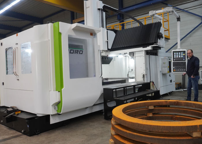 Edwin Klap, directeur van K&G Machining, naast de nieuwe Hartford SW-220 portaalfreesmachine. De machine wordt ingezet om grote ringen te bewerken tot flenzen.