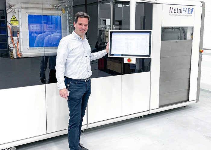 Egon Seegers van ABB Turbocharging bij de MetalFAB1 3D-metaalprinter. Hiermee kunnen reserveonderdelen sneller worden geproduceerd en hoeven ze minder op voorraad te worden gehouden.