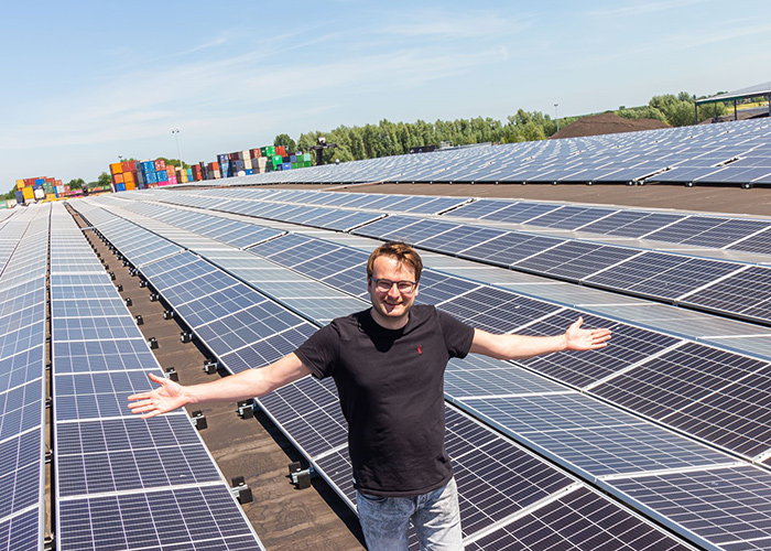 Tom Haan, tactisch inkoper bij Simian, tussen de zonnepanelen op het dak van de drukkerij in Westerbroek: “Door je te laten begeleiden door professionals, weet je zeker dat je niks over het hoofd ziet. Dat is heel geruststellend.”