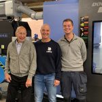 Drie generaties Lebrun bij het nieuwe 5-assig simultaan bewerkingscentrum DVF 5000 van DN Solutions dat meerdere bewerkingen achter elkaar kan uitvoeren. V.l.n.r. Hannes, Edwin en Julian Lebrun.