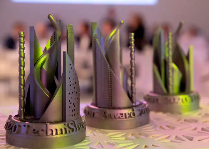 De winnaar van de TechniShow Innovatie Award ontvangt tijdens de Avondshow op de stand van FPT-Vimag de ge-3D-printe Award.
