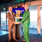 Jessica Peters-Hondelink, directeur bestuurder van de Amsterdam Economic Board, feliciteert Techport-voorzitter Mark Denys, en overhandigt het cadeau: een olijfboompje.