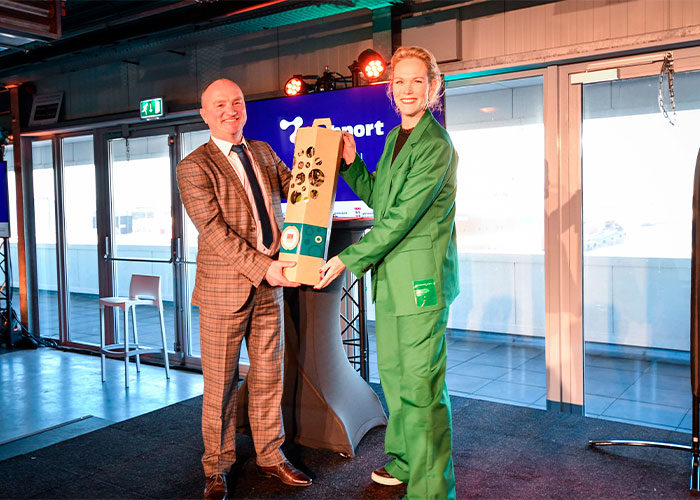 Jessica Peters-Hondelink, directeur bestuurder van de Amsterdam Economic Board, feliciteert Techport-voorzitter Mark Denys, en overhandigt het cadeau: een olijfboompje.