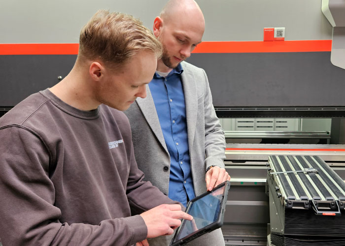 Sinds Koolmees live is gegaan met het nieuwe ERP-systeem hebben de medewerkers in de productie hun eigen tablet, waarop ze alle opdrachten en informatie krijgen. Op de foto Jether Kooiman, CNC-kanter/Operator lasersnijder bij Koolmees, en Gijs Krukkert van Halloy, die Koolmees ondersteunt bij de implementatie en optimalisatie van de ERP software.