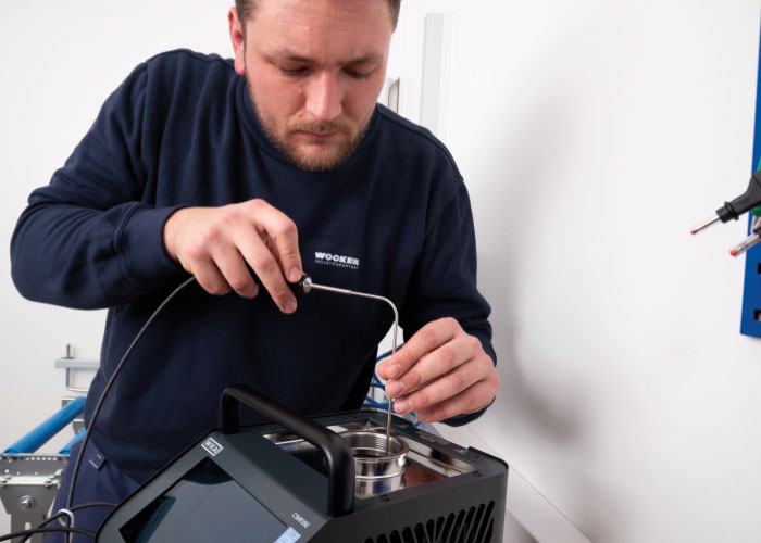 Service-technicus Leon Kuper bereidt een temperatuurkalibratie voor met de positionering van de referentiesensor.