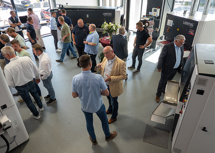 De gasten bij de opening nemen een kijkje bij de machines voor ontbramen, kantenafronding en oppervlaktefinishing die in het Demo Center staan opgesteld, gereed voor demonstraties en testen.