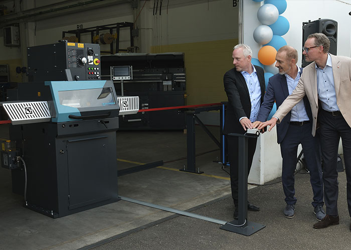 In plaats van een lint door te knippen, activeerde de burgemeester van Lörrach, Jörg Lutz, met een druk op de knop een speciaal geproduceerde cirkelzaag, die symbolisch door een metalen staaf sneed. Ook aanwezig: Rene Eger, Managing Director van Kaltenbach Cutting Systems, en Stephan Toxopeüs, CEO van de Kaltenbach Group.