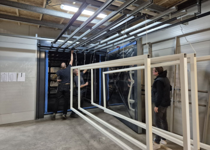 Een aantal stalen deuren wordt in de oven geschoven. Deze oven is een laagfrequent infraroodoven, een eigen ontwikkeling van AVA Luchttechniek. Hierin verwarmen gasbranders spiralen in de oven tot ruim 200 graden Celsius.