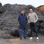 Henk van der Stouwe (l) en Lars Blaak voor een grote berg spanen. Maandelijks verwerkt Emmer Schroot- en Metaalhandel ongeveer 700 ton metaalspanen van bedrijven uit Noord-Nederland en -Duitsland.